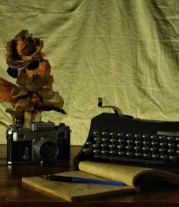 camera, journal, and typewriter on a desk